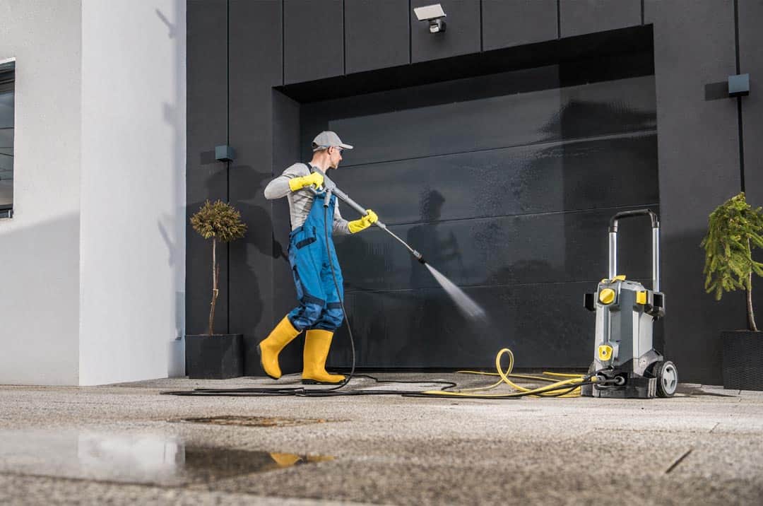 Men Pressure Washing His Garage Gate